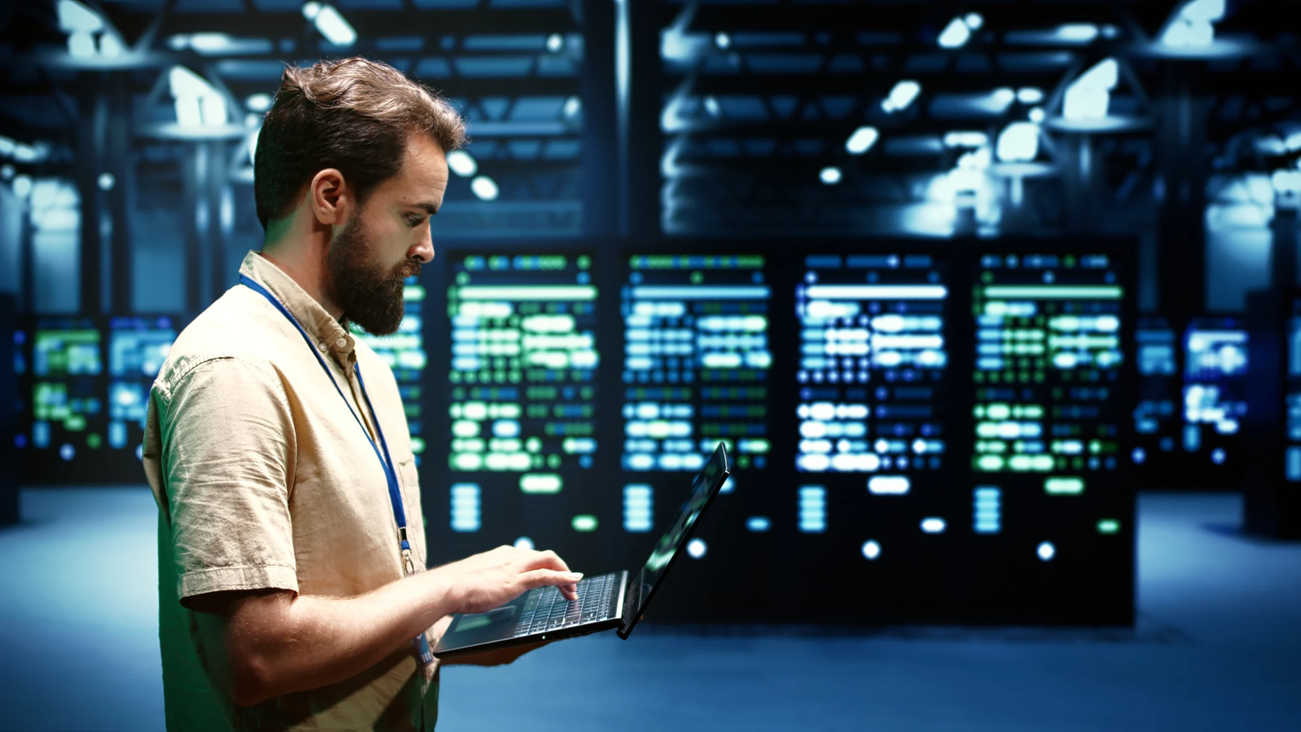 IT engineer working on laptop in a modern data center with servers in background